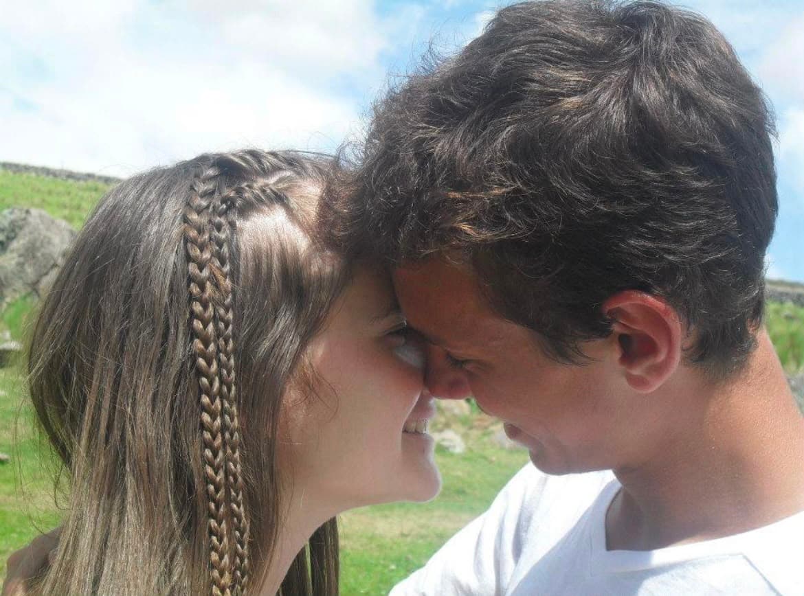 Yesu y Juli, frente con frente, sonriendo al aire libre